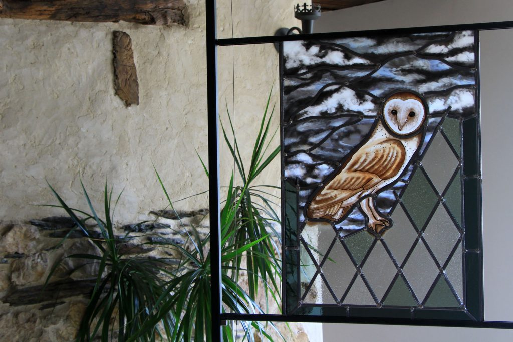 Création vitrail originale d'Eclipse Vitrail représentant une chouette effraie peinte sur une vitrerie traditionnelle en losange